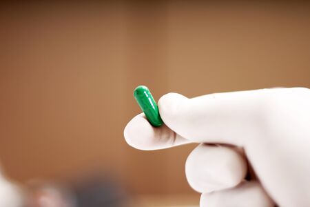 Picture of man holding capsule medicine in hand. Isolated on white background.
