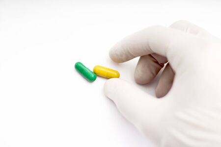 Picture of man holding capsule medicine in hand. Isolated on white background.