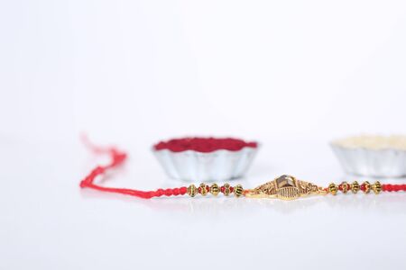 Indian festival: Raksha Bandhan background with an elegant Rakhi, Rice Grains and Kumkum. A traditional Indian wrist band which is a symbol of love between Brothers and Sisters.の写真素材