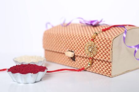Indian festival: Raksha Bandhan background with an elegant Rakhi, Rice Grains and Kumkum. A traditional Indian wrist band which is a symbol of love between Brothers and Sisters.の写真素材