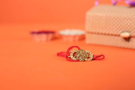 Indian festival: Raksha Bandhan background with an elegant Rakhi, Rice Grains and Kumkum. A traditional Indian wrist band which is a symbol of love between Brothers and Sisters.の写真素材