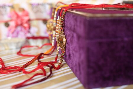 Indian festival: Raksha Bandhan background with an elegant Rakhi, Rice Grains and Kumkum. A traditional Indian wrist band which is a symbol of love between Brothers and Sisters.の写真素材