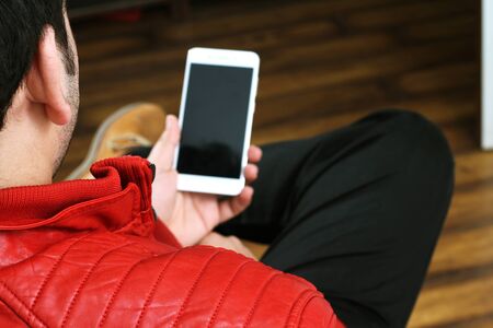 Picture of man holding a mobile in hand. Isolated on white background.