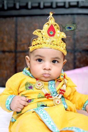 Picture of Indian Little child wearing Lord Krishna costume and celebrating Janmashtami festival. Isolated white background.の写真素材