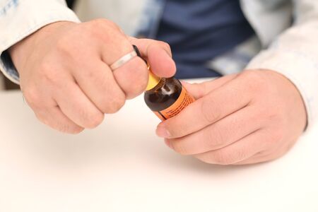 Picture of man drop medicine bottle holding in hand. Isolated on white background.