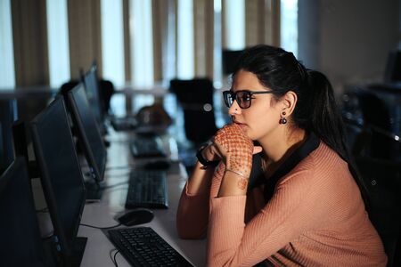 Young businesswoman sitting at desk working using computer, modern executive girl at the office.の写真素材