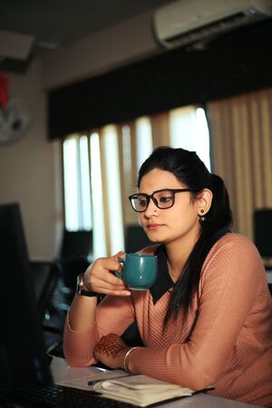Young businesswoman sitting at desk working using computer, modern executive girl at the office.の写真素材