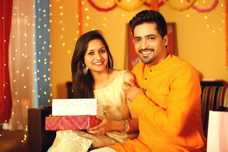 Indian couple is Celebrating Diwali. Isolated on decorative background.の写真素材