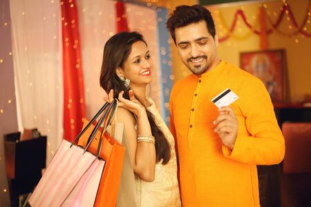 Indian couple is Celebrating Diwali. Isolated on decorative background.の写真素材