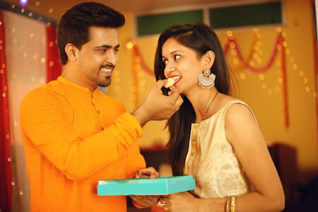 Indian couple is Celebrating Diwali. Isolated on decorative background.の写真素材