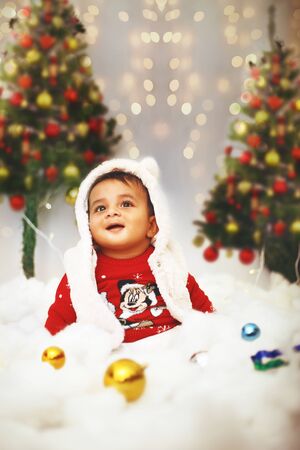 Little cute baby celebrating christmas festival with in decorative background on the occasion.