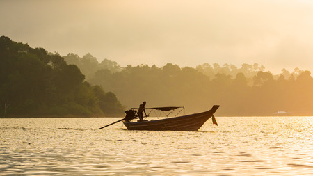 The boat working in morning in lake,beautiful in natureの写真素材