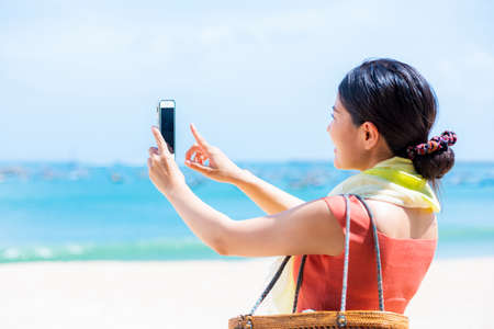 The woman who takes the photograph of the seaの写真素材