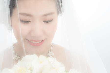 A bride smiling with a wedding veilの写真素材