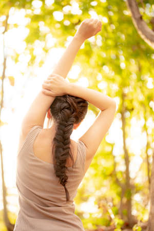 The back of a woman doing gymnastics in the forest