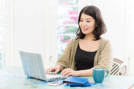 a woman who operates a computer in a bright roomの写真素材