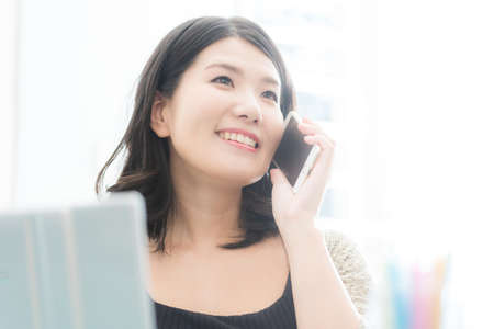A woman who operates a computer and a smartphoneの写真素材