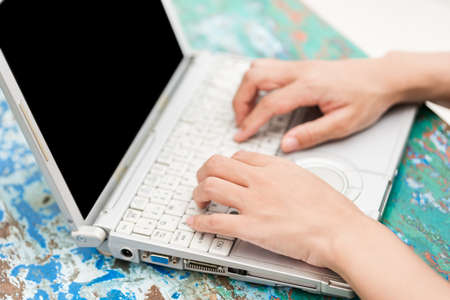 Close-up of a woman's hand typing on a computer keyboardの写真素材