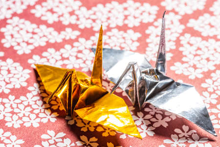 Gold and silver paper cranes on a Japanese backgroundの写真素材