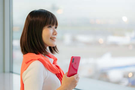Traveller woman operating smartphone at airport