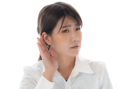 asian woman listening to something with hand on ear isolated on white background