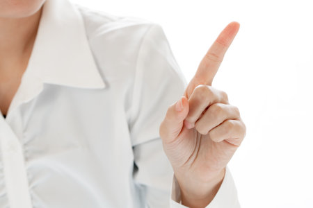 <p>Businesswoman pointing at something on white background. Focus on hand.</p>の写真素材