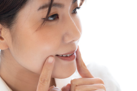 Young woman taking care of her teeth, closeup portrait on white background.の写真素材