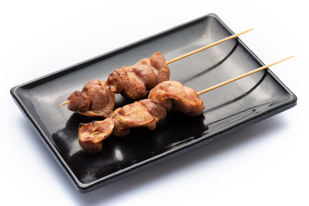 Gizzard grilled chicken on black plate isolated on white background.の写真素材