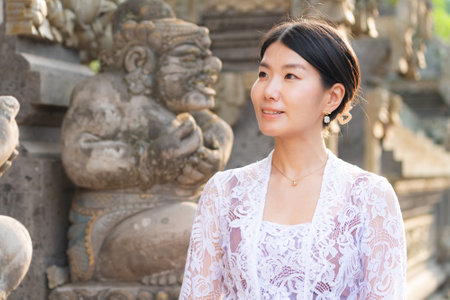 Portrait of a young Asian woman in front of a temple.の写真素材