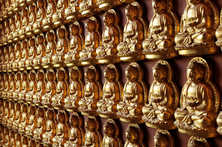 Several Buddha Statue were stick on the wall in side temple. These several small statue are golden shine make us peaceful for Buddhist and for all people.のeditorial素材