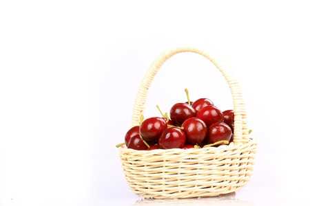 Basket with ripe wet cherry isolated on a whiteの写真素材