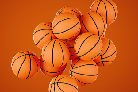 Many classic orange basketball balls isolated on orange backgroundの写真素材