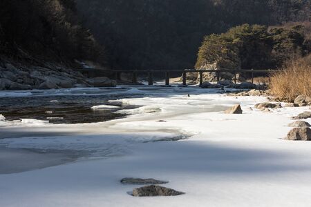 Frozen river and bridge, winter mountain landscape, Gangwon-do, South Korea.の写真素材