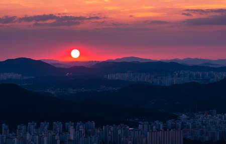 Beautiful red sunset landscape in the city. Hoamsan Mountain in Seoul, South Korea.の写真素材