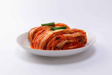 Korean kimchi. Korean traditional cabbage kimchi on white plate. White background, frontal closeup.の写真素材
