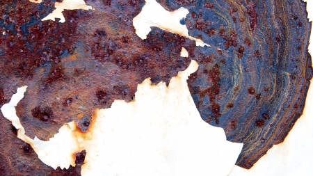 Intricate colorful rust patter on a painted surface in need of repairの写真素材