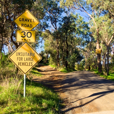 gravel road warning sign in rural australiaの写真素材
