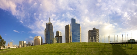 View of Melbourne city with a rising grassy foreground and construction vehiclesの写真素材