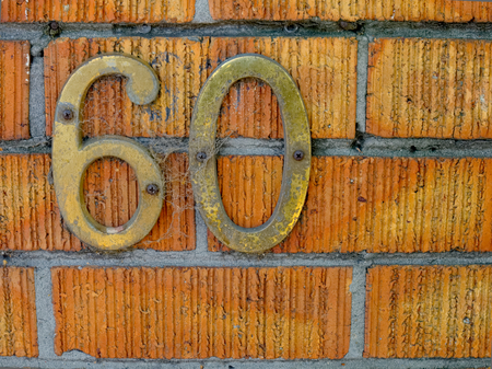 the number sixty on a brick wallの写真素材