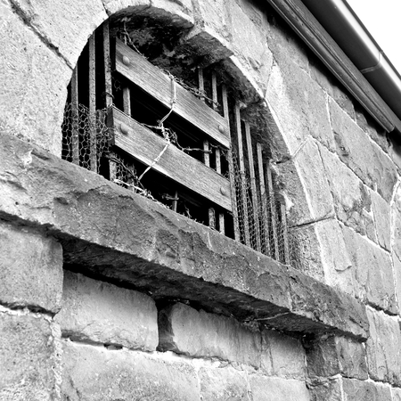 bluestone wall with barbed wire and bars on windows