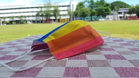 Yellow orange and red mask on a chequered sheet. A concept is for pride month and encourage LGBTQIA communities around the globe.の写真素材
