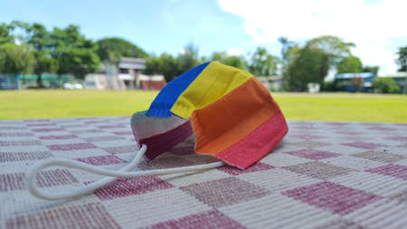 Yellow orange and red mask on a chequered sheet. A concept is for pride month and encourage LGBTQIA communities around the globe.の写真素材