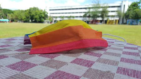 Yellow orange and red mask on a chequered sheet. A concept is for pride month and encourage LGBTQIA...