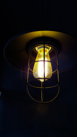 Antique electric lamp with yellow light and black casingの写真素材