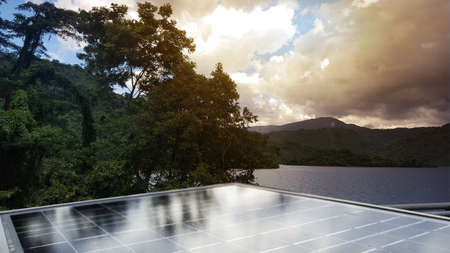 Small solar cell panels with the sunlight and blue sky, installed at a remote house closed to...