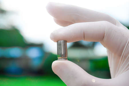 Blur pistol bullet shells holding in white gloved fingersの写真素材