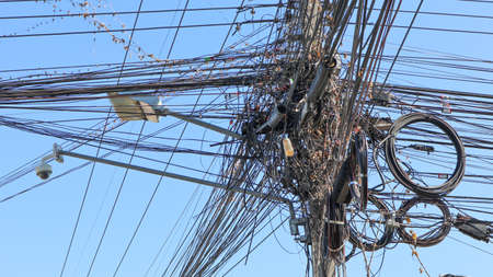 Confused communication wires on an electrical poleの写真素材