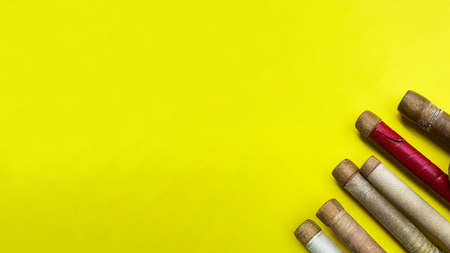 Brown wooden cricket handles which are bound by cotton yarn and artificial leather on yellow backgroundの写真素材