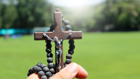 Brown rosary wooden cross holding in hand soft and selective focus on the crossの写真素材