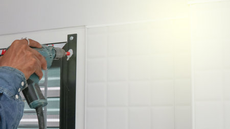 Technician inspects a window frame which is new installed a mosquito wire screenの写真素材